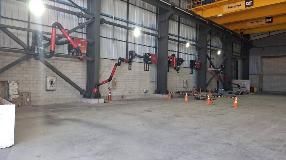 Brazos de extracción instalados en un taller industrial