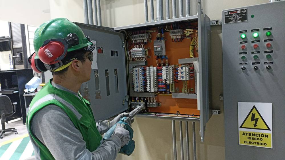 Técnico realizando mantenimiento en un tablero eléctrico