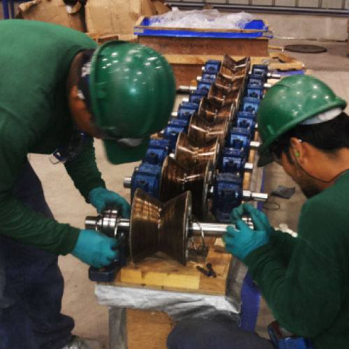 Técnicos de SERELMEG realizando mantenimiento a un componente mecánico