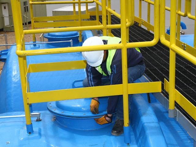 Técnico operando equipos en una planta de tratamiento de aguas residuales